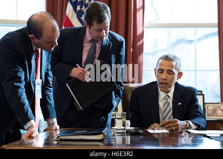 US-Präsident Barack Obama verleiht mit nationalen Sicherheit Stellvertretender Advisor Ben Rhodes (links) und Speechwriting Senior Director Terry Szuplat vor dem weißen Haus Gipfel am Kampf gegen gewalttätigen Extremismus im Weißen Haus Oval Office 18. Februar 2015 in Washington, DC. Stockfoto