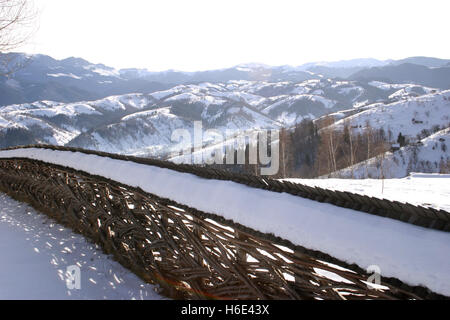 Winter in den Karpaten. Im Vordergrund ist der mit Schnee bedeckte Zaun. Stockfoto