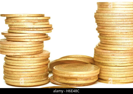 Wirtschaftliche Konzepte. Goldene Münzen auf weißem Hintergrund. Münzen, die auf einander gestapelt sind. Stockfoto
