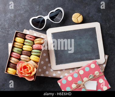 Bunte Makronen und Blackboard. Süßen Macarons am Steintisch. Draufsicht mit textfreiraum für Ihren text Stockfoto