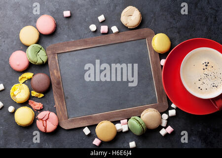 Bunte Makronen, Kaffee und Tafel. Süßen Macarons am Steintisch. Draufsicht mit textfreiraum für Ihren text Stockfoto