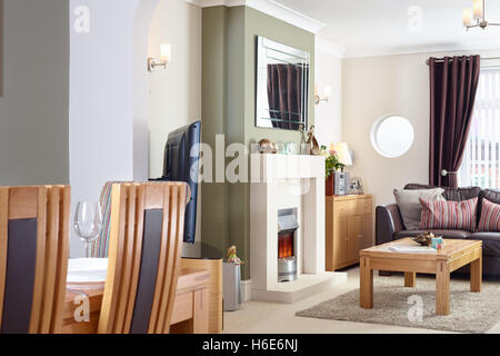 Ein offenes Wohnzimmer, Esszimmer mit Kamin & elektrische Feuer in einem modernisierten uk Home Stockfoto