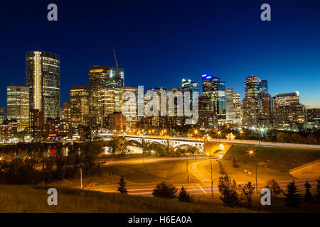 Die Innenstadt von Skyline von Calgary kurz nach Sonnenuntergang zur blauen Stunde zeigt Centre Street Bridge über den Bow River und den umliegenden sk Stockfoto