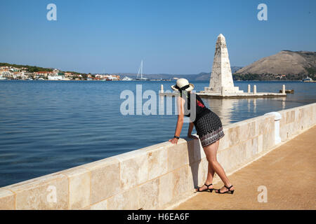 Frau mit Hut auf der Drapano-Brücke, die den Blick auf die Stadt Argostoli auf der griechischen Insel Kefalonia Griechenland bewundert Stockfoto