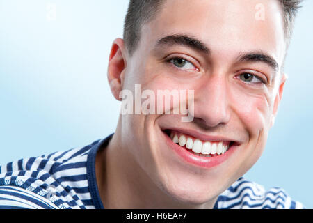 Makro Gesicht Porträt hübscher junger Mann mit gesunden Zähnen, die auf der Suche zur Seite. Stockfoto