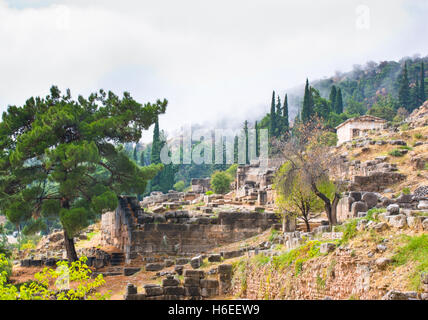 Die Ruinen des antiken Delphi mit dem Athener Finanzministerium auf dem Hintergrund, Griechenland. Stockfoto