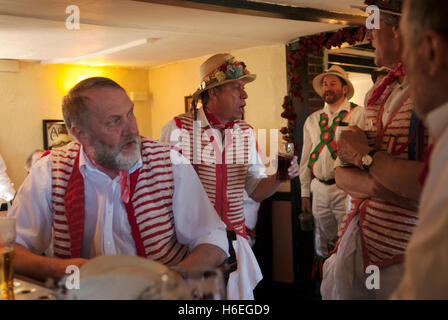 Village Pub UK Inneneinrichtung Menschen. Morris Männer entspannen sich während einer Pause vom Tanzen. Traditionelle Volkslieder singen, Thaxted Essex 2000s HOMER SYKES Stockfoto