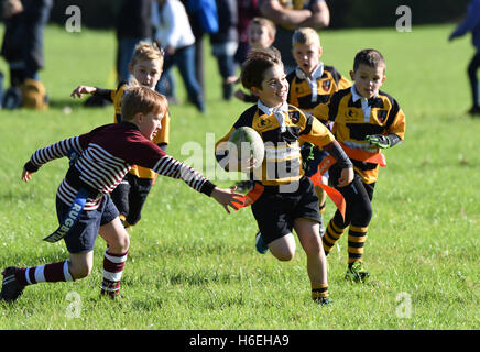 Glücklich lächelnder Junge spielt Junior Kinder Tag Rugby Spiel Aktion Großbritannien Großbritannien Kinder Kinder Sport gesunde Aktivität Sport Jungen Sport Stockfoto