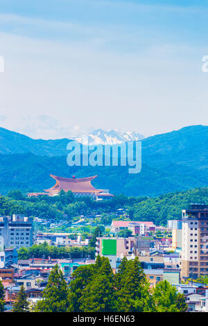 Stadt Takayama, Sukyo Mahikari World Headquarters und schneebedeckten Bergkette in Schichten unter leicht bewölktem Himmel in Gifu Pre Stockfoto