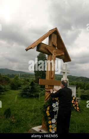 Mann, der betet am Holzkreuz, aufgewachsen in Erinnerung an die Opfer des Kommunismus in Sighet, Rumänien Stockfoto