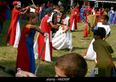 Jungen im mittelalterlichen thematische Ferienlager vorgibt, Schwertkampf Stockfoto