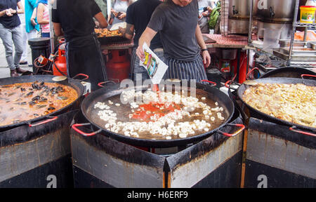 Ein Mann Kochen Paella für Touristen in einer Straße stehen Stockfoto