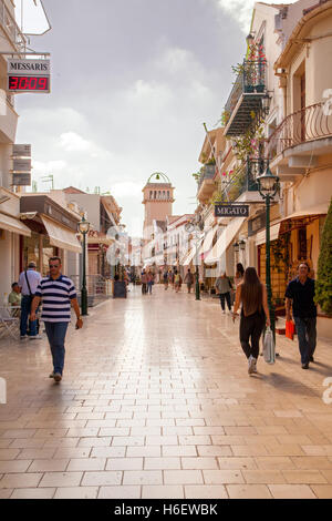 Touristen zu Fuß und shopping entlang der marmorierten überdachte Hauptstraße in Argostoli auf der griechischen Insel Kefalonia Stockfoto