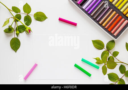 Weißer Tisch Schreibtisch, Draufsicht, flach lag. Pastell, Bleistift, Papier, Rosenblüten. Stockfoto