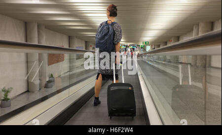 Eine Frau auf einem Travelator am Flughafen von Palma auf Mallorca. Stockfoto