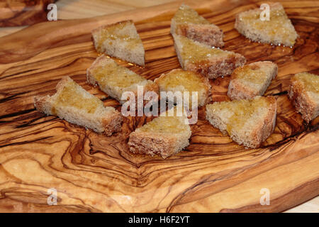 Scheiben Brot gegrillt mit Olivenöl auf Holzbrett, italienische Snacks Stockfoto