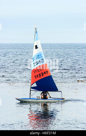 Eine einzige Segler segeln auf einem ruhigen See bei Ringstead Bay, Dorset, England, Großbritannien Stockfoto