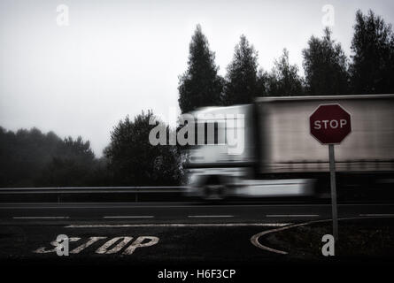Foto von LKW, die Beschleunigung auf Straße, Stop-Schild und Stop Buchstaben gemalt in den Boden Stockfoto