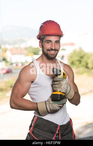 Erfolgreichen männlichen Architekten auf eine Baustelle mit Bohrer Stockfoto