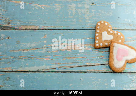 Winter-Lebkuchen mit handgefertigten Sahnehäubchen auf einem blauen Holztisch. Herzförmige, sternförmigen und Weihnachtsbaum geformt. Stockfoto
