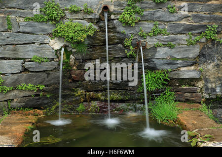 Steinbrunnen mit drei Wasserstrahlen fallen Stockfoto