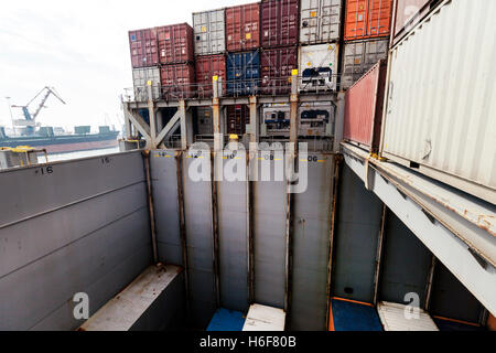 Blick auf einem Frachter Schiff Ablagefach, halbvoll mit Containern, in der Mitte des Ladevorgangs. Stockfoto