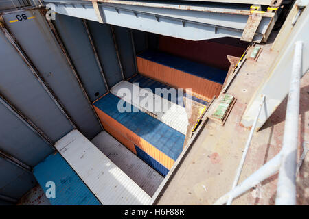 Blick auf einem Frachter Schiff Ablagefach, halbvoll mit Containern, in der Mitte des Ladevorgangs. Stockfoto