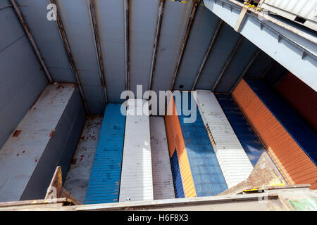 Blick auf einem Frachter Schiff Ablagefach, halbvoll mit Containern, in der Mitte des Ladevorgangs. Stockfoto