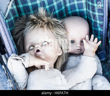 Zwei alte Puppen im Kinderwagen in verlassenen Berghaus. Stockfoto