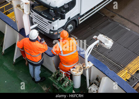 Schiffs-Crew-Mitglieder in orange Workwear beobachten LKW einsteigen Fähre von P & O North Sea Ferries Stockfoto