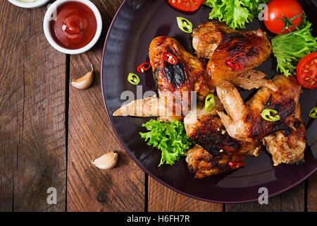 Gebackene Hühnerflügel im asiatischen Stil auf Platte. Ansicht von oben Stockfoto