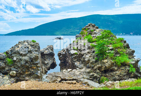 Die großen Steinen im Wasser sind die Fragmente der mittelalterlichen Festung gefallen vom Berg, Herceg Novi, Montenegro. Stockfoto