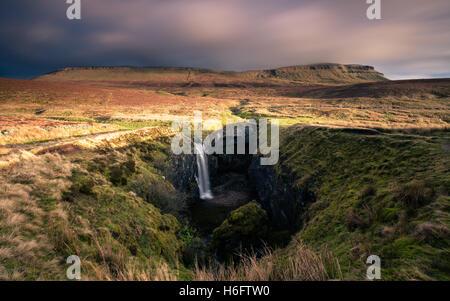 Nach starkem Regen ein Wasserfall in Hull Topf mit Pen-y-Gent im Hintergrund, Yorkshire Dales National Park, England, UK fließt Stockfoto