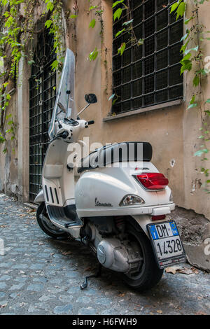 Italienische Vespa Roller parkten in einer Straße mit Kopfsteinpflaster von Rom, Latium, Italien Stockfoto