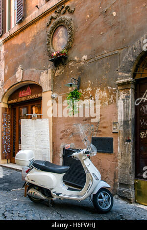 Italienische Vespa Roller parkten in einer Straße mit Kopfsteinpflaster von Rom, Latium, Italien Stockfoto