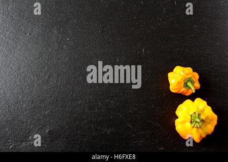 gelbe Scotch Bonnet Chilischoten auf dem Schiefer Teller Stockfoto