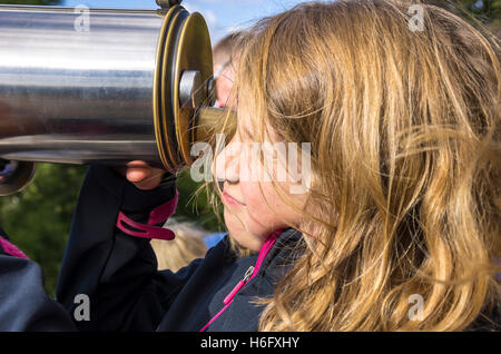 Acht Jahre altes Mädchen durchsucht ein Teleskop. Stockfoto