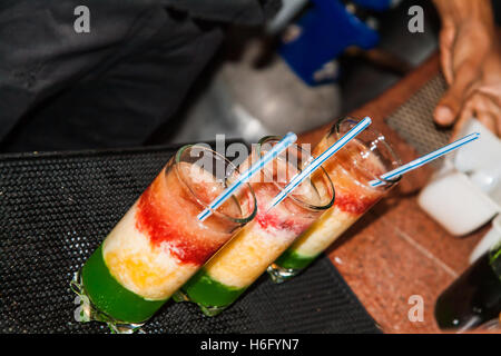 der Barkeeper an der Bar macht den dreischichtigen Cocktail. Stockfoto