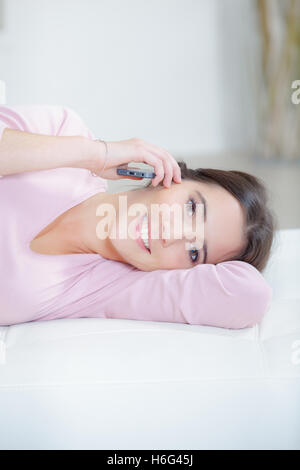 Junge Frau liegend und telefonieren Stockfoto