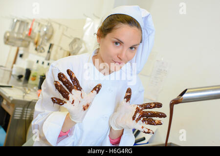 Koch mit Schokolade an Fingern Stockfoto