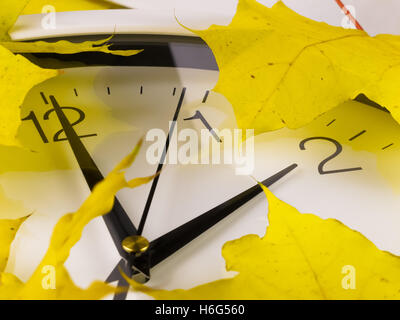 Herbst, Winterzeit. Uhr mit gelben Blätter. Stockfoto