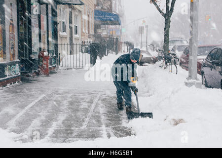 Junge Schaufeln Bürgersteig während Schneesturm. Brooklyn. New York City/USA Stockfoto