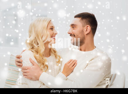 glückliches Paar zu Hause auf Sofa umarmt Stockfoto