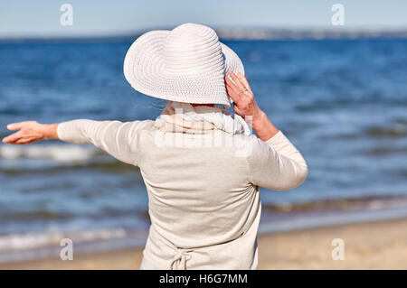 glücklich senior Frau Sonnenhut Sommer Strand Stockfoto