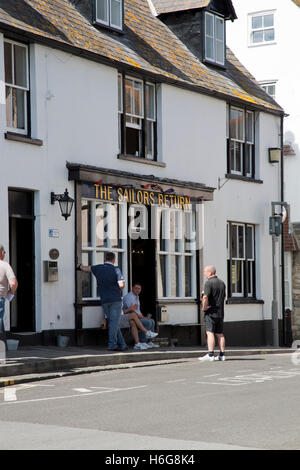 Männer genießen einen Drink zur Mittagszeit vor einem Pub im Hafen von Weymouth, Dorset Stockfoto