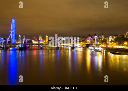 Eine nächtliche Foto von Waterloo Bridge Suche entlang der Themse gegenüber dem London Eye und Big Ben. Stockfoto