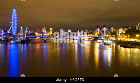 Eine nächtliche Breitbild-Foto von Waterloo Bridge Suche entlang der Themse gegenüber dem London Eye und Big Ben. Stockfoto