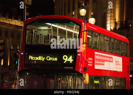 Nachtzeit Busse fahren durch einen hell beleuchteten und beleuchtete Piccadilly Circus in central London, UK Stockfoto