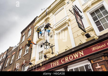 Maler und Dekorateure Abseilen das äußere des Hauses Krone Öffentlichkeit auf Monmouth Street, London, WC2 Stockfoto