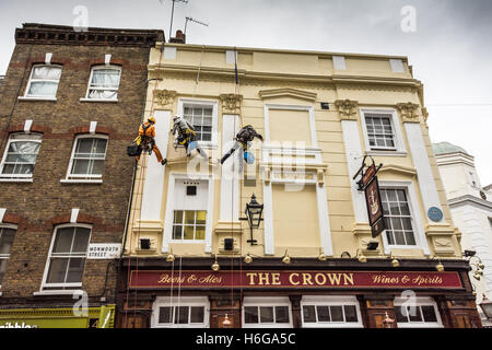 Maler und Dekorateure, die das Äußere des öffentlichen Hauses Crown in der Monmouth Street, London, WC2 abseilen Stockfoto